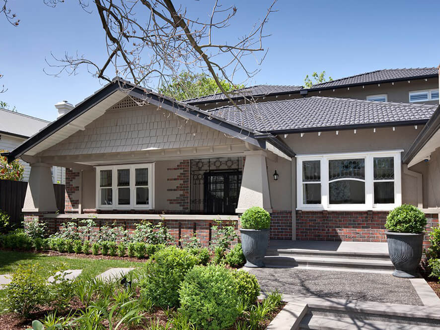 Painted Brick Modern Design with White Window Trims and Tiled Porch with Green Garden